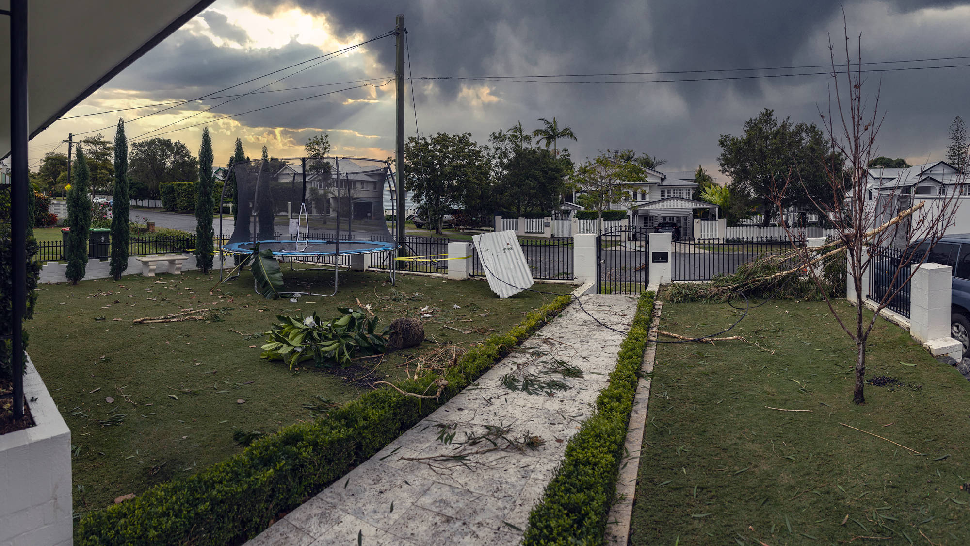 Front yard damaged after a storm with debris and powerlines down