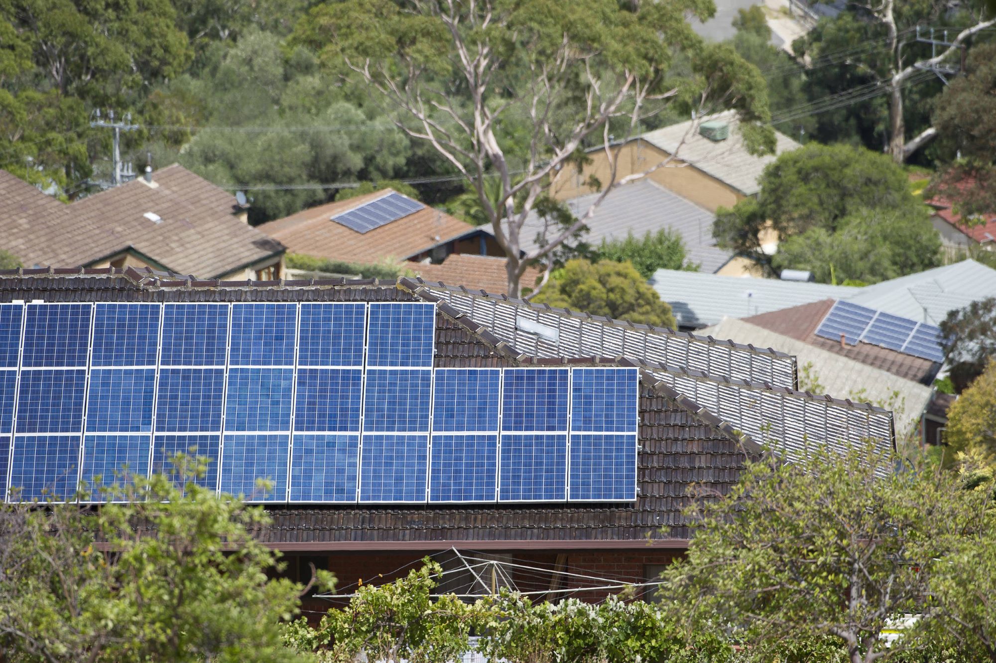 Aerial view of multiple solar panels on the roof of residential house