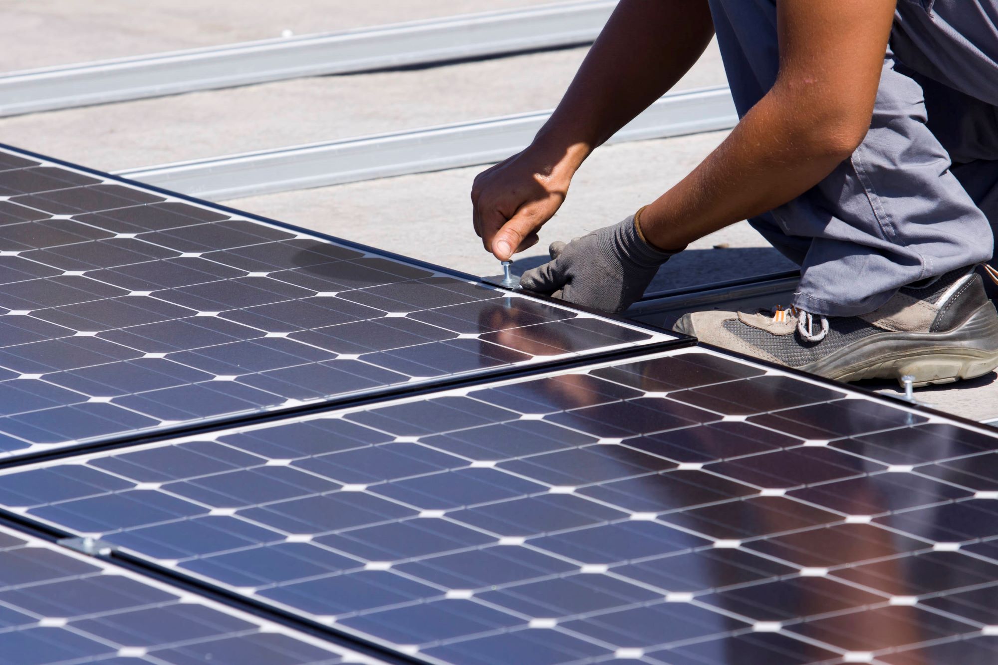 A man installing solar panels on a roof