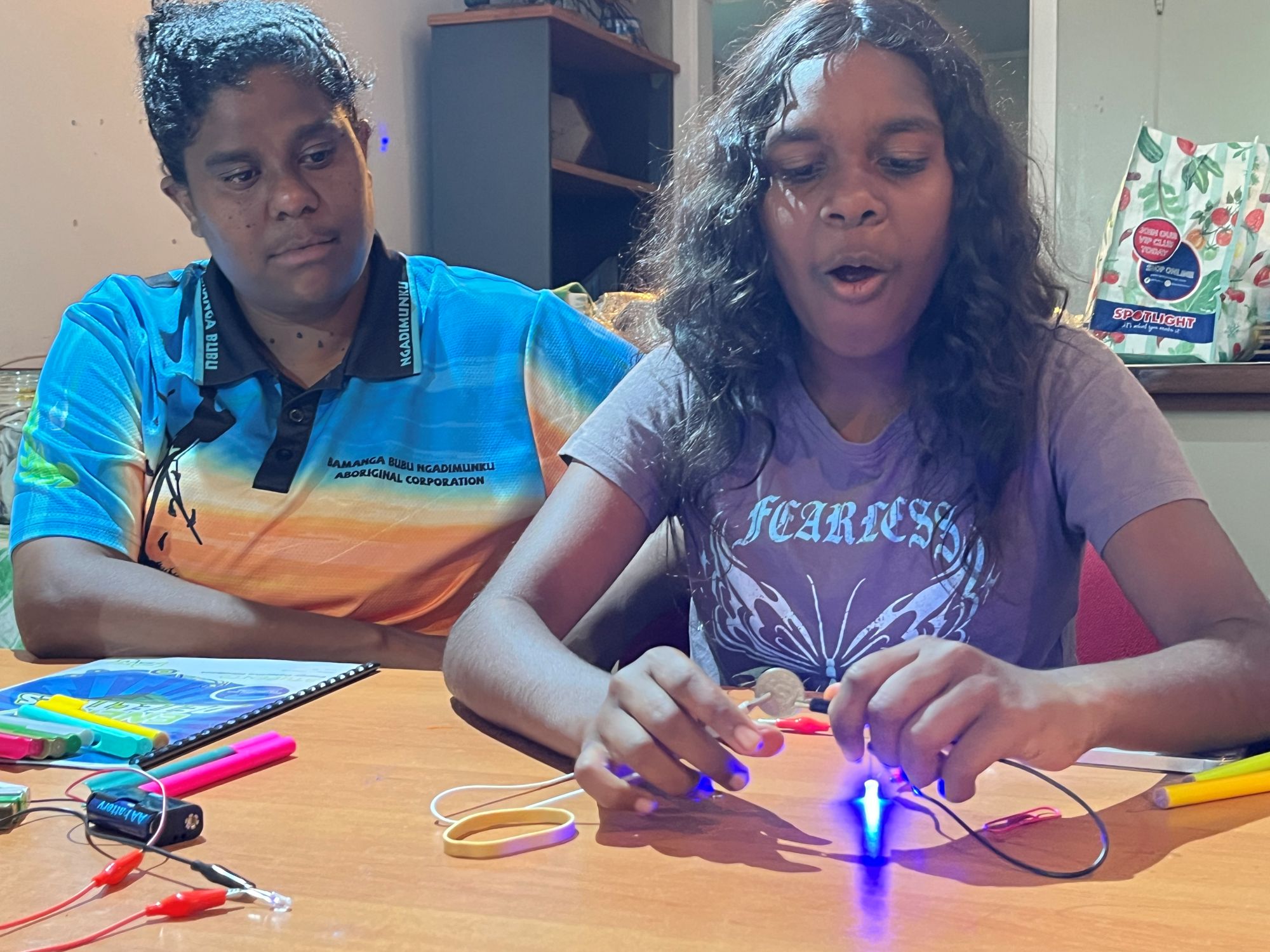 Two children at a table learning about electricity