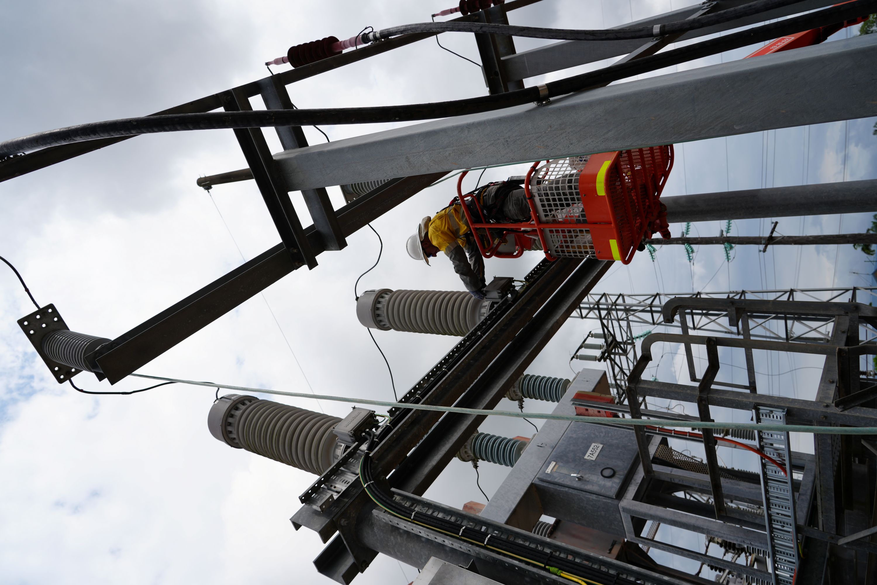 Crew in ornage lift working on Ingham substation close up