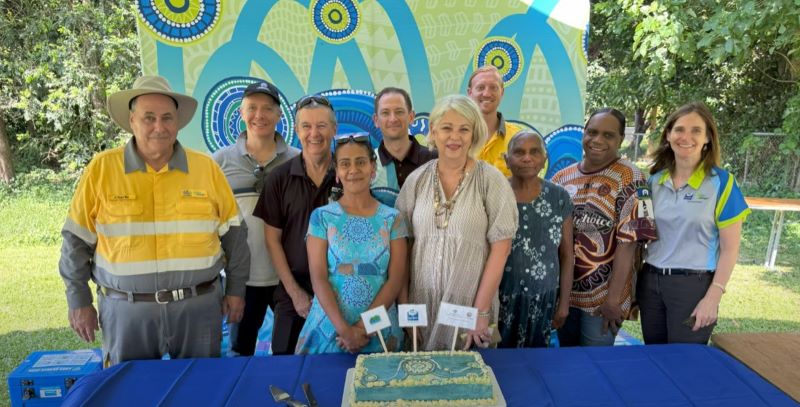 Group photo of community and Ergon Energy employees with birthday cake