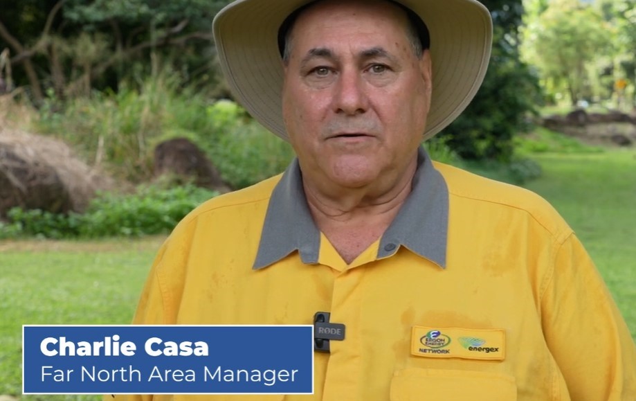 Field crew employee Charlie Casa on grass with bush in the background