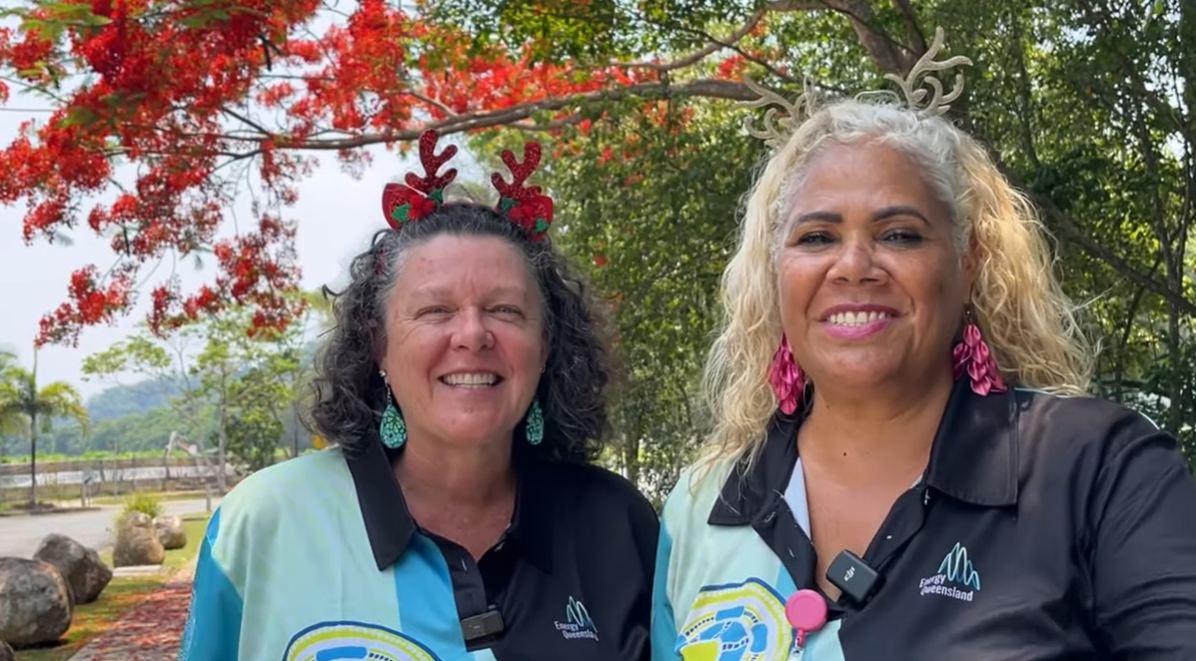 Two Ergon Energy Network employees in front of a tree
