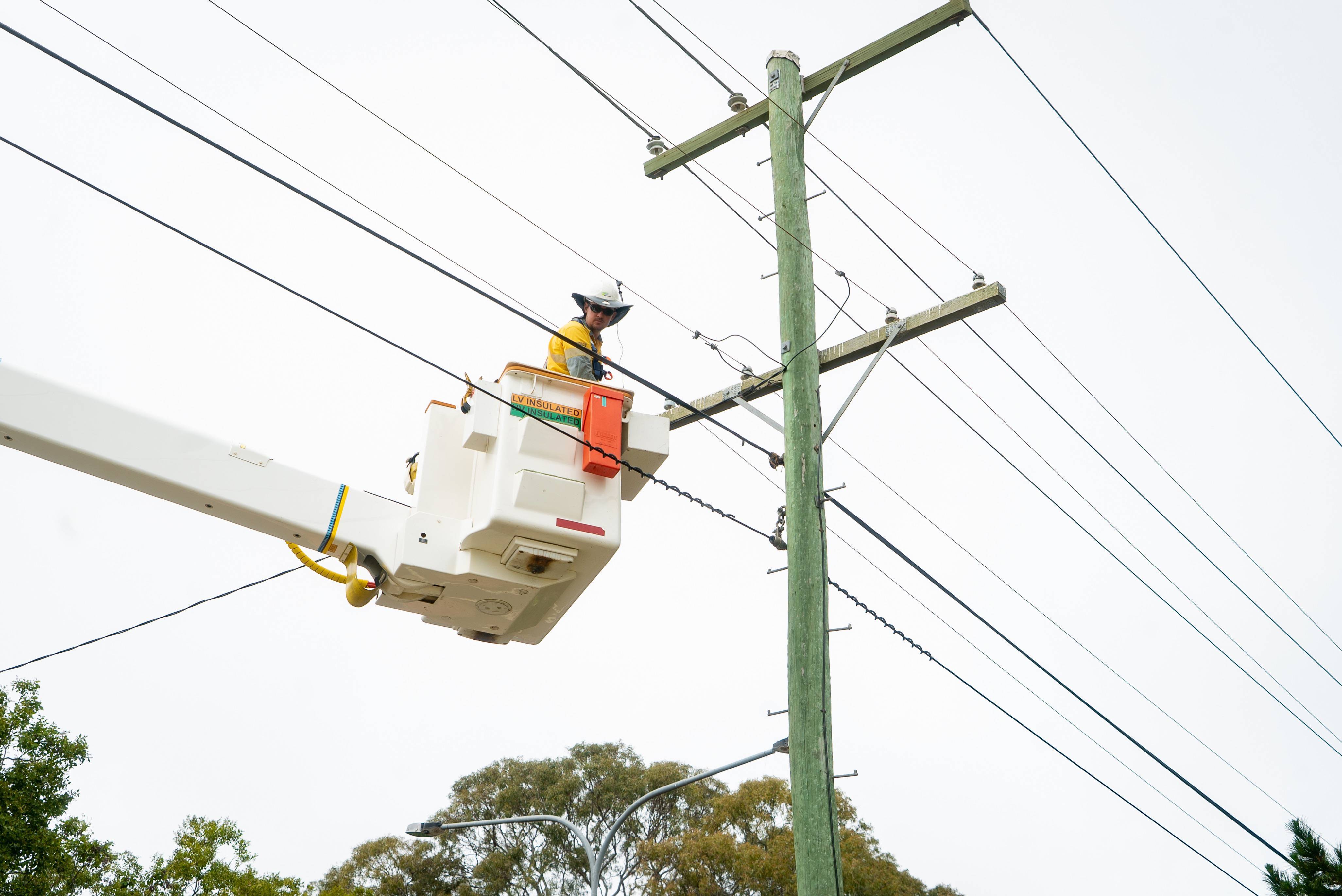 Field crew in a cherry picker working on powerlines