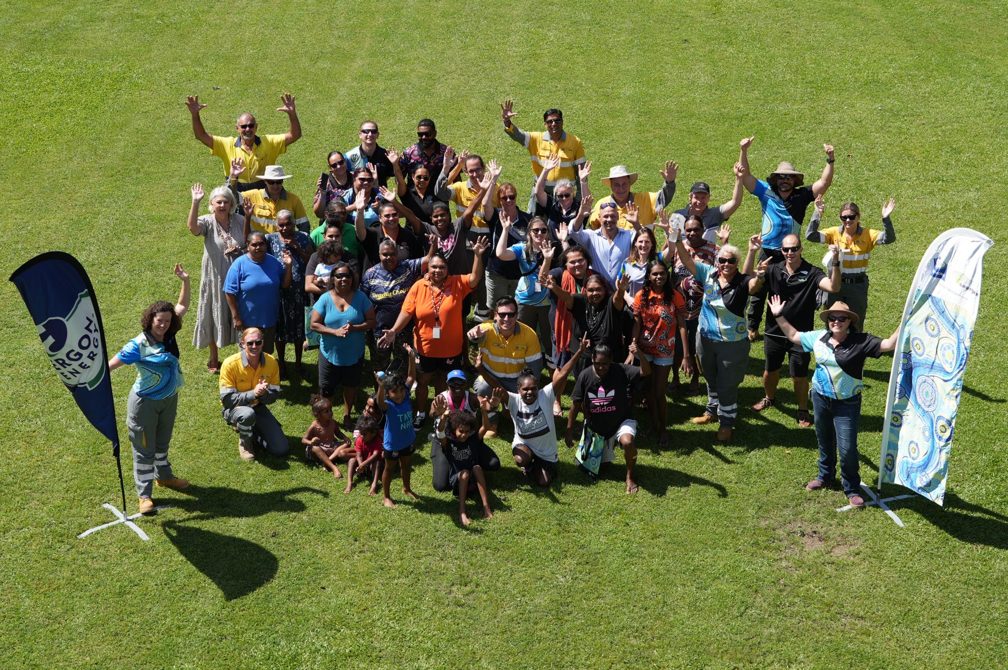 Aerial view of group of people on the lawn with hands in the air