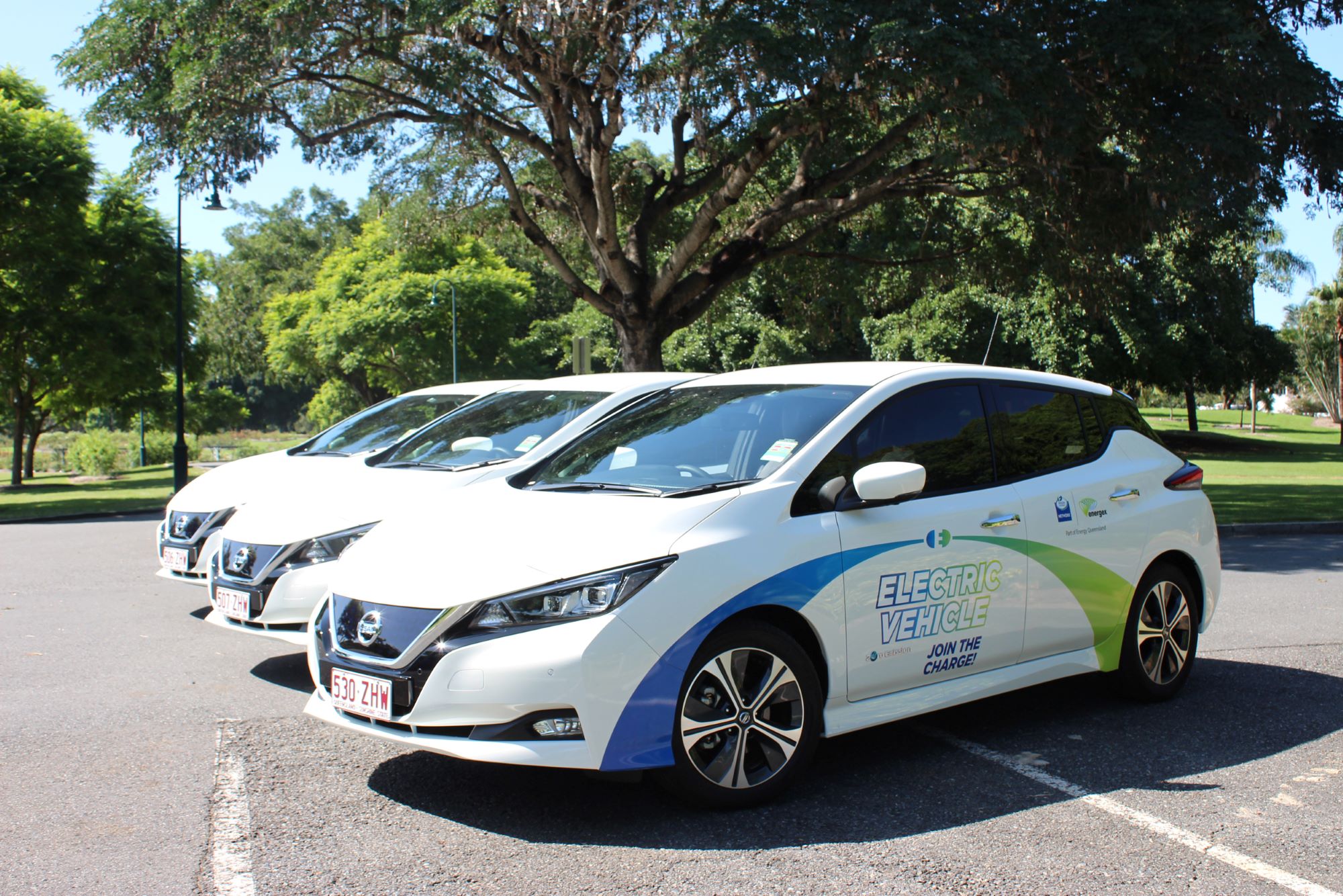 3 branded EVs lined up in a car park