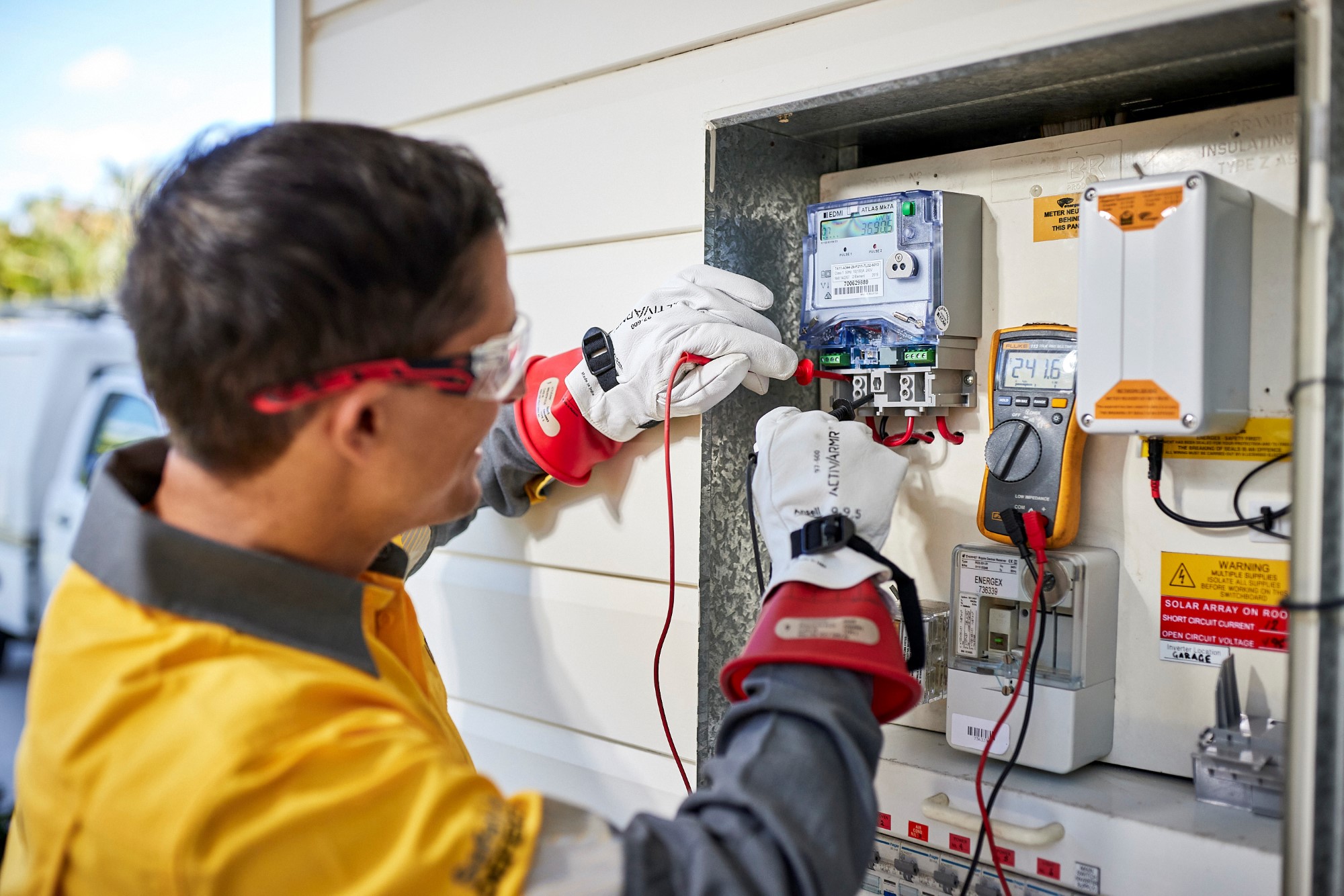 Field staff worker testing a meter on the side of a residential house