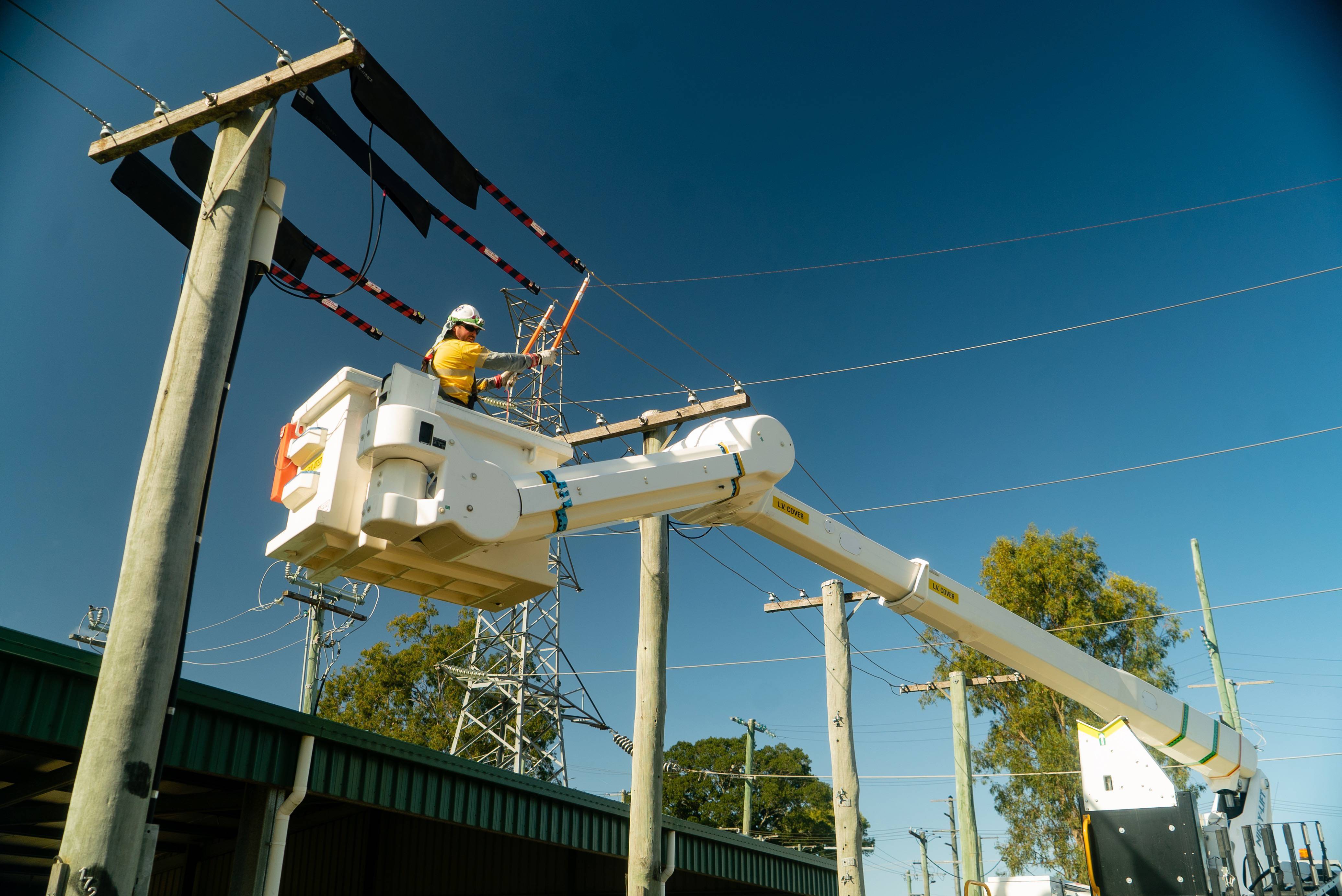 Field crew working in cherry picker near powerlines